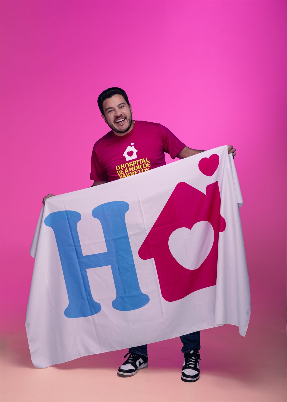 Jadyel Alencar segurando bandeira com símbolo do Hospital do Amor